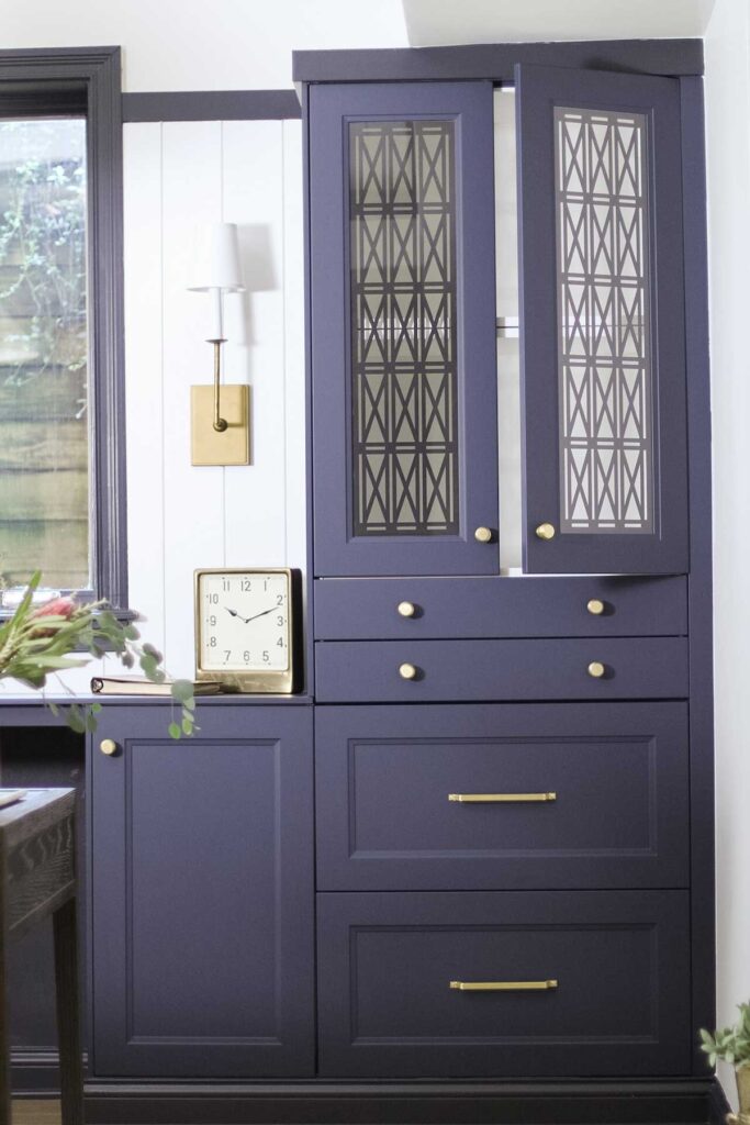 Navy blue office cabinets with metal screens and brass hardware.