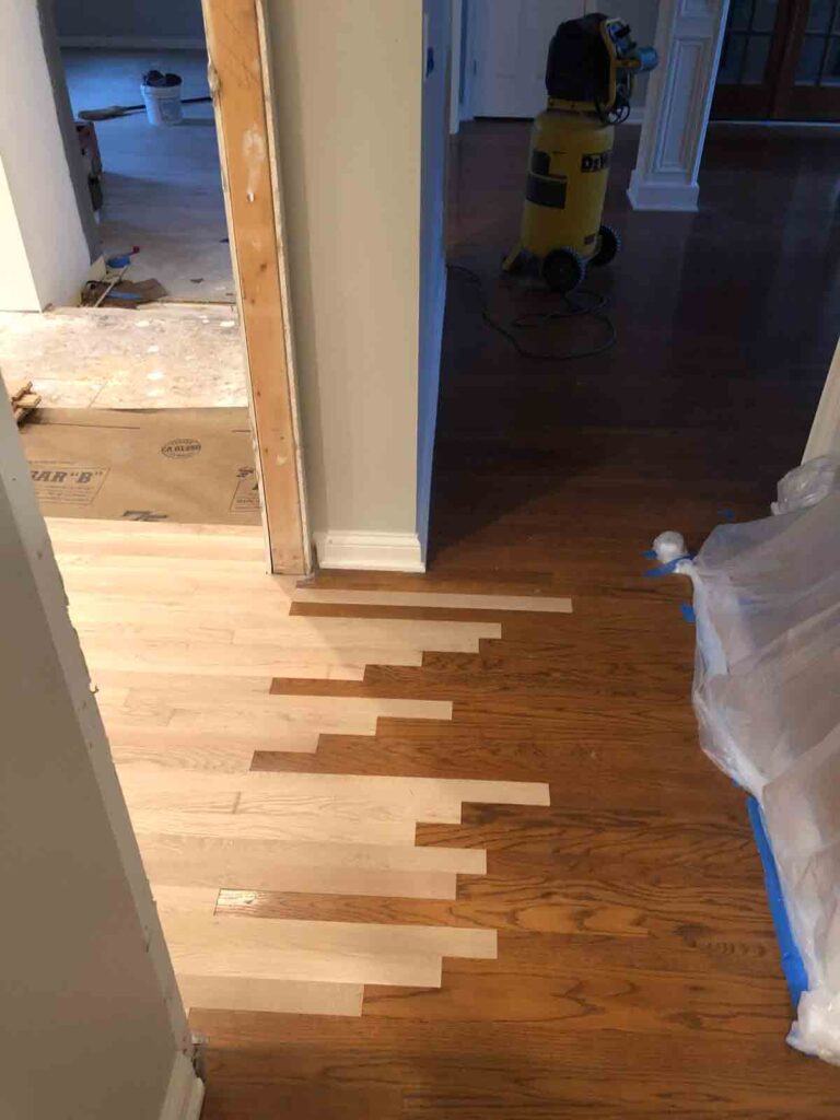 Patching of existing hardwood floors with new hardwood floor planks. 