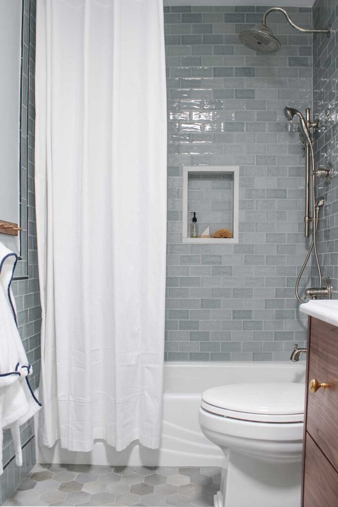 Bedrosians Marin blue subway tile with warm gray grout on shower walls. Bedrosians celine blue hex tile on floors.  