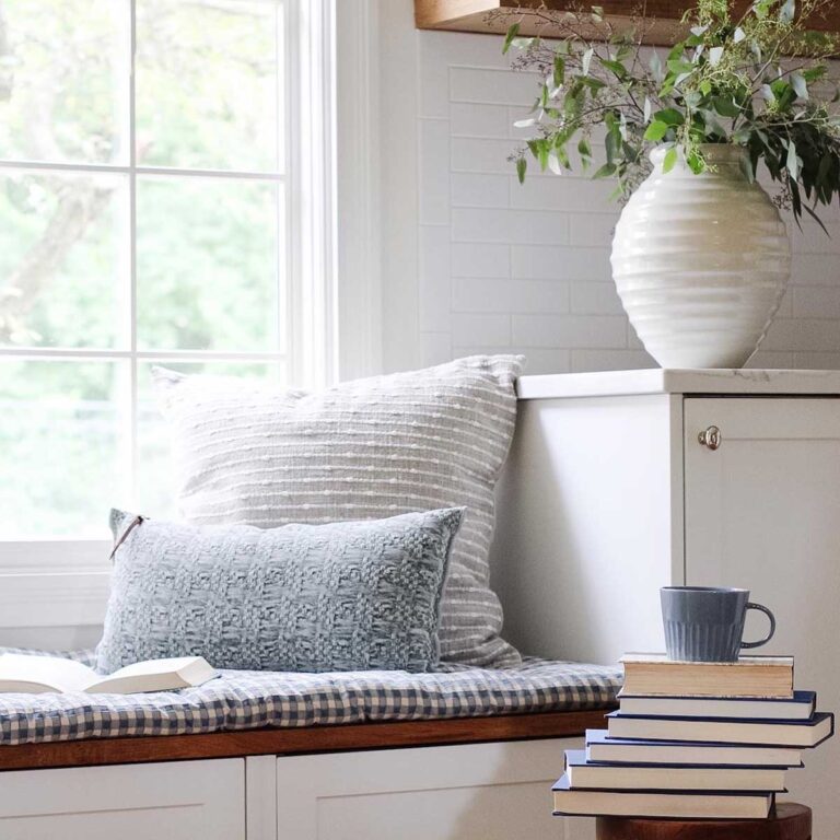 window seat with pillows and a stack of books