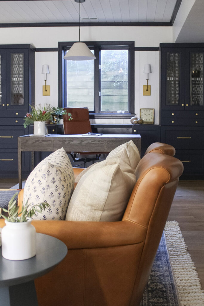 Home office area with leather chairs and blue cabinets in the background